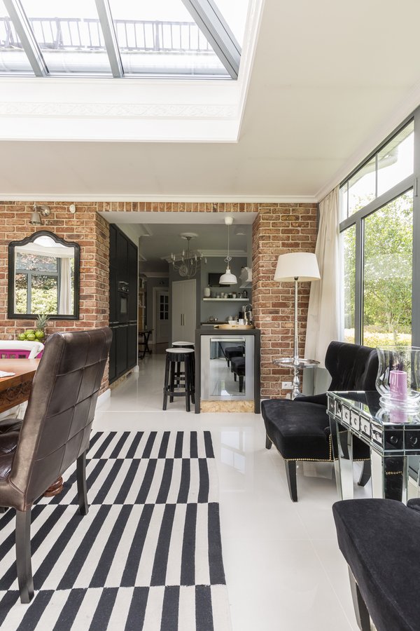 Open-plan orangery and kitchen connection with exposed brick piers and roof lantern — Hampshire Build
